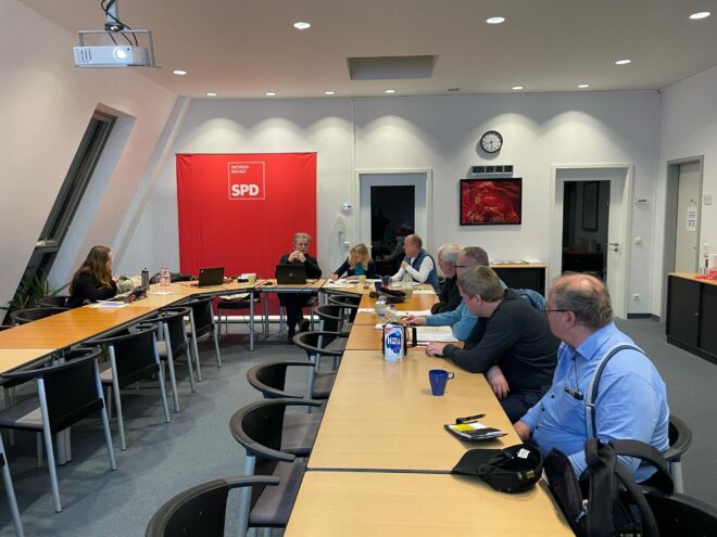Personen sitzen an einem Tisch in U-Form